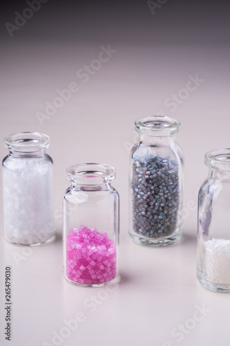 Varied colors beads in transparent bottles white background