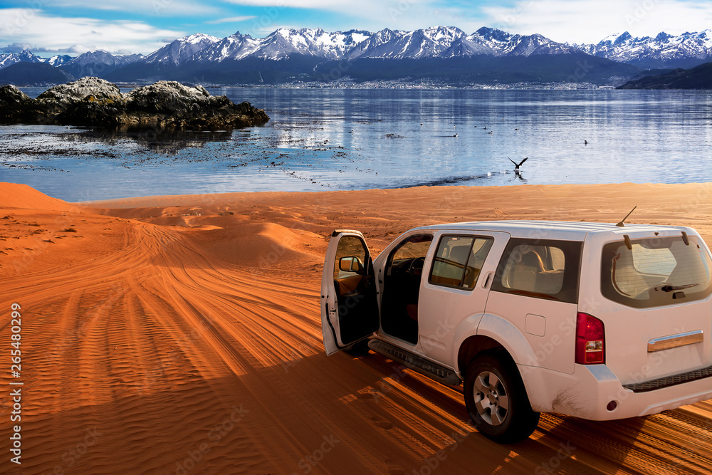 Φωτογραφία Off-road vehicle on a desert sand track and the antartic sea in the background