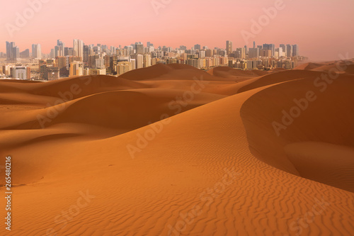 Dunes of Desert at dawn and skyscrapers of Dubai (United Arab Emirates)