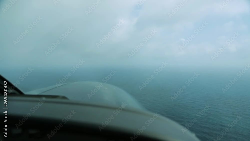 Wide still shot from an aircraft's cockpit of calm blue sea water as it gets lower, heading towards its landing Island, Great Barrier Reef. Wide still shot from an aircraft's cockpit of calm blue sea water as it gets lower, heading towards its landing Island, Great Barrier Reef.