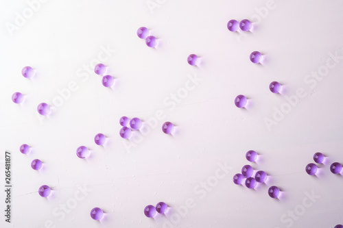 Purple scattered marbles on white background top view