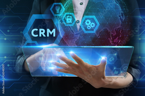 The concept of business, technology, the Internet and the network. A young entrepreneur working on a virtual screen of the future and sees the inscription: CRM