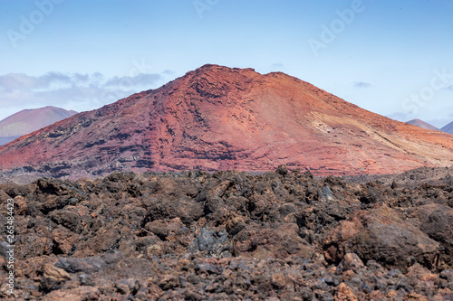 Red volcano near Los Hervideros caves in Lanzarote, Canary Islands. Spain