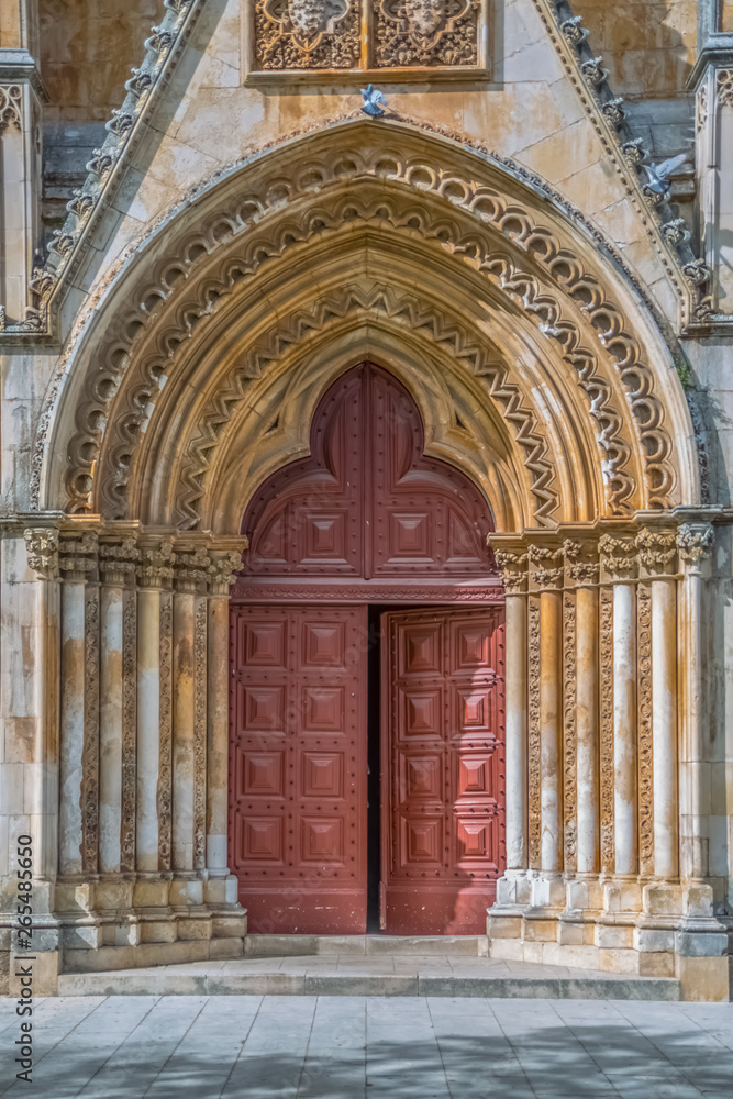 Detail view at the frontal gate and door of the ornate Gothic exterior facade of the Monastery of Batalha literally the Monastery of the Battle, in Leiria, Portugal