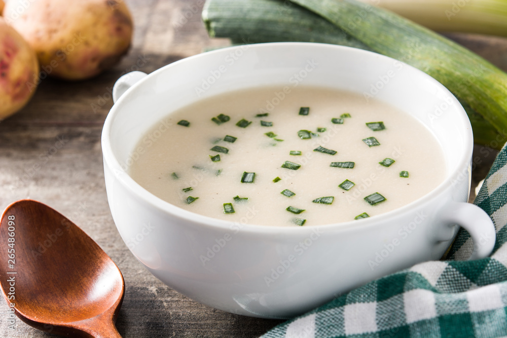 French vichyssoise soup in bowl on wooden table French vichyssoise soup in bowl on wooden table