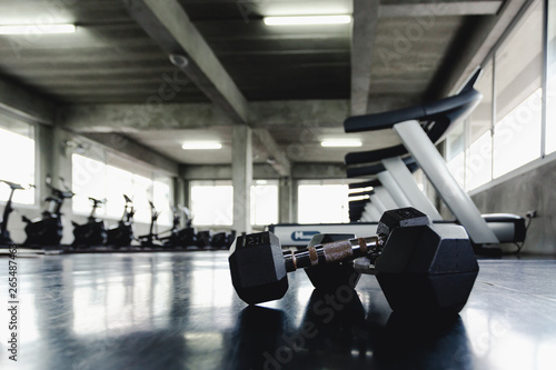 Background view back and white equipment dumbbells on floor in the gym sport center