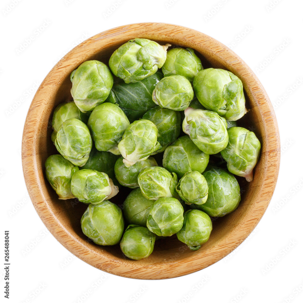 Fresh raw organic brussels sprouts in wooden bowl isolated on white. Top view, close-up. Fresh raw organic brussels sprouts in wooden bowl isolated on white. Top view, close-up.