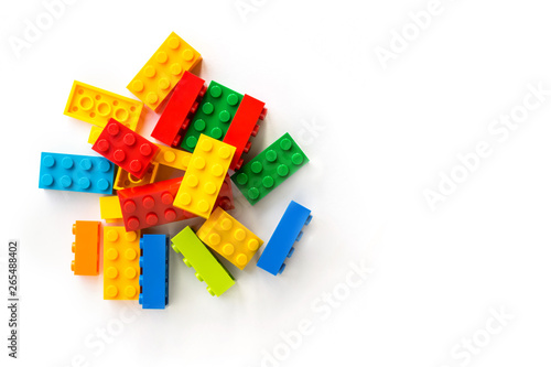 Bunch of Multicolor Plastick constructor bricks on white background. Popular toys. Copyspace