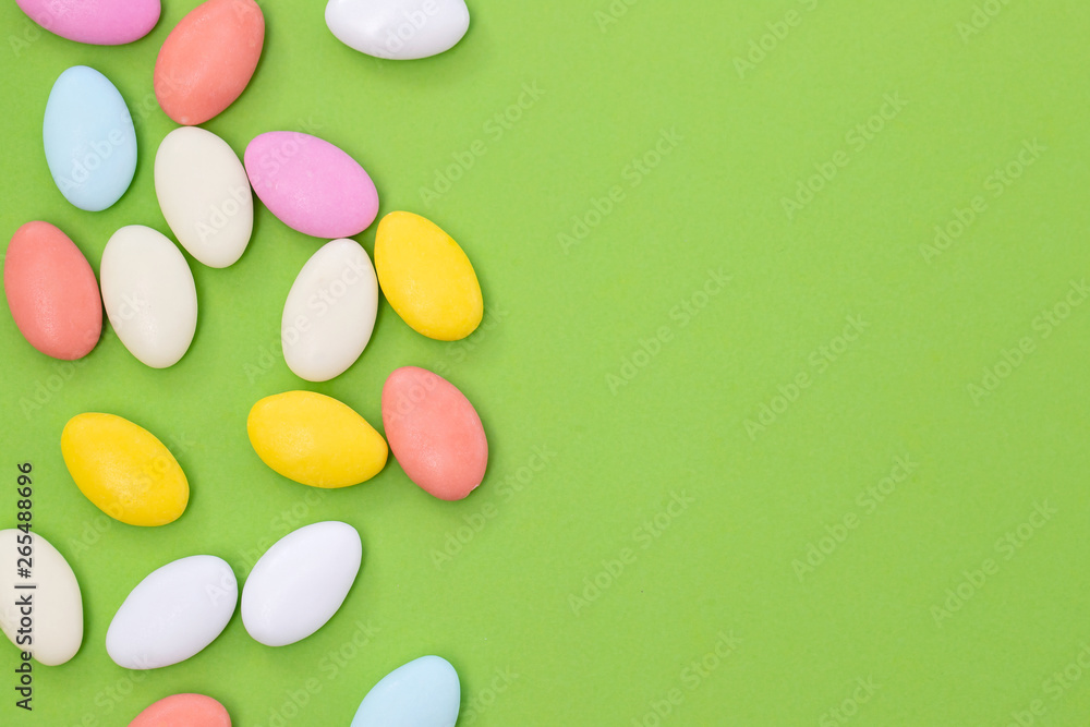 close up of chocolate egg and candy drops on green background close up of chocolate egg and candy drops on green background