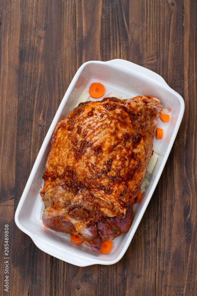 raw turkey leg with spices and vegetables on dish on wooden background raw turkey leg with spices and vegetables on dish on wooden background