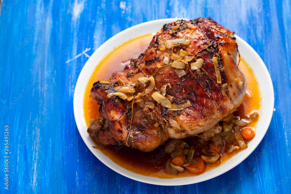 baked turkey leg with vegetables and herbs on white dish baked turkey leg with vegetables and herbs on white dish