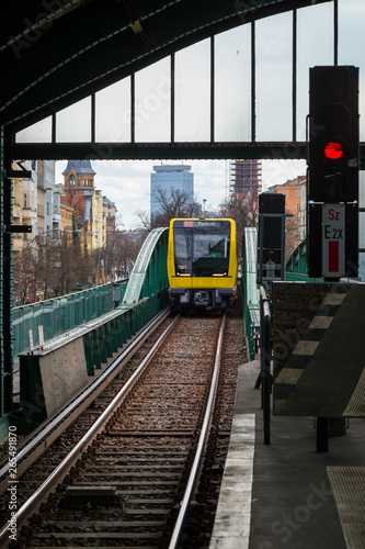 New yellow subway train approaching an overground Eberswalder Strasse U-Bahn station in Berlin, Germany. photo