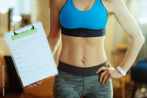 Closeup on fit sports woman in modern house showing meal plan