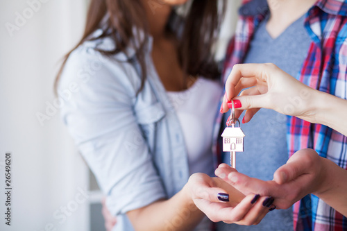 Young happy couple moving into their new home. They unpacking and cleaning new home