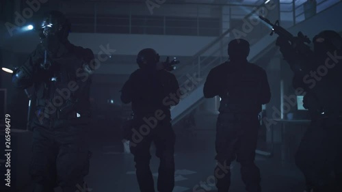 Wallpaper Mural Masked Team of Armed SWAT Police Officers Slowly Move in a Hall of a Dark Seized Office Building with Desks and Computers. Soldiers with Rifles and Flashlights Surveil and Cover Surroundings. Torontodigital.ca