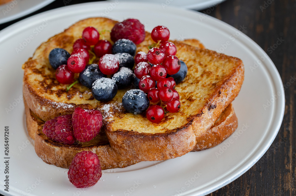 Close up of French toasts with fruit on the plate. Restaurant menu image. Close up of French toasts with fruit on the plate. Restaurant menu image.