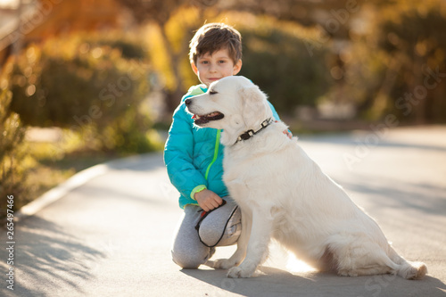 baby boy with a dog breed Golden Retriever on a walk best friends