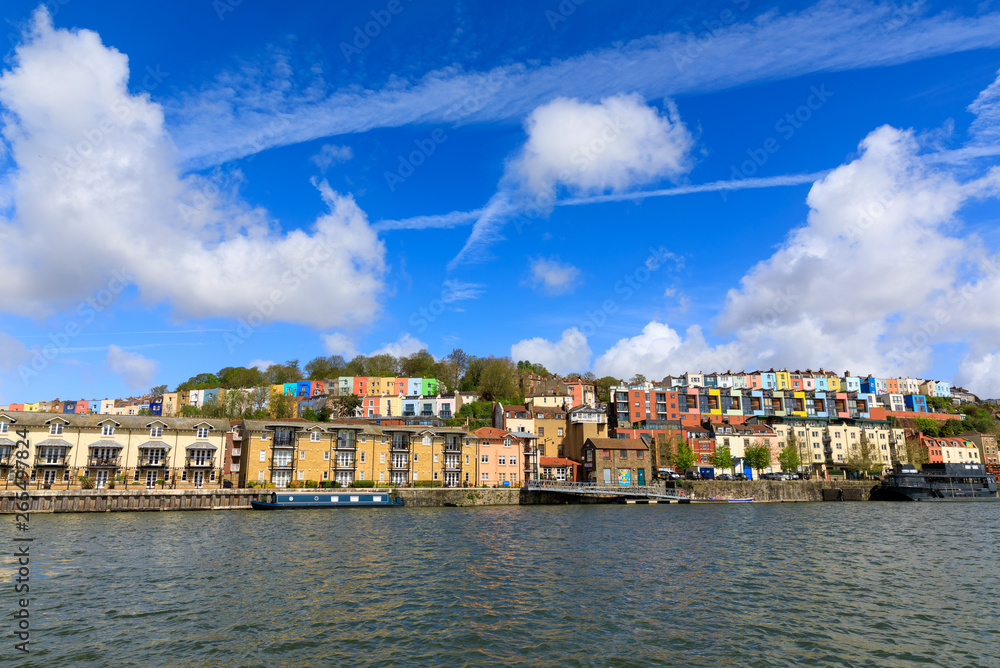 View across the river Avon of fluffy clouds over colourful houses of Bristol (UK).