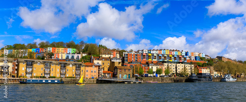 View across the river Avon of fluffy clouds over colourful houses of Bristol (UK).