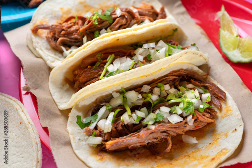 Mexican beef barbacoa tacos on colorful background