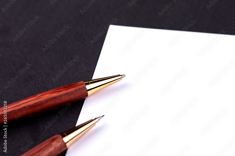 Luxury pen and mechanical pencil in wood and gold with a white sheet of paper Luxury pen and mechanical pencil in wood and gold with a white sheet of paper