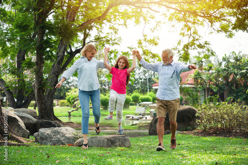 Happy grandfather, grandmother with granddaughter playing in summer day, Family relaxing in the garden © amorn