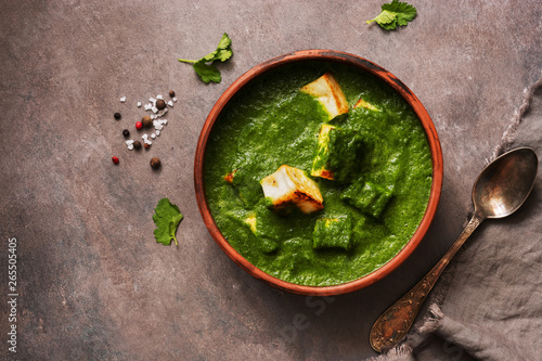 Palak paneer or Spinach and Cottage cheese curry on a dark background. Traditional Indian food. Top view, copy space. photo