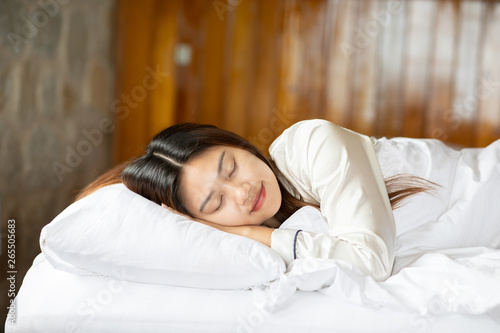 Beautiful Attractive Asian woman wearing Pajamas sleep close her eyes smile sleep and sweet dream on bed in bedroom in the morning feeling so relax and comfortable,Healthcare and Sleep Concept