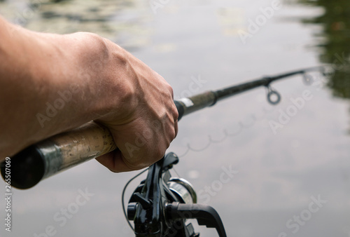 man catches fish on a telescopic fishing pole with a coil