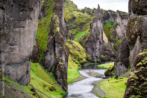 Landscape high angle view of canyon in Fjadrargljufur, Iceland with large cliffs and river green moss grass