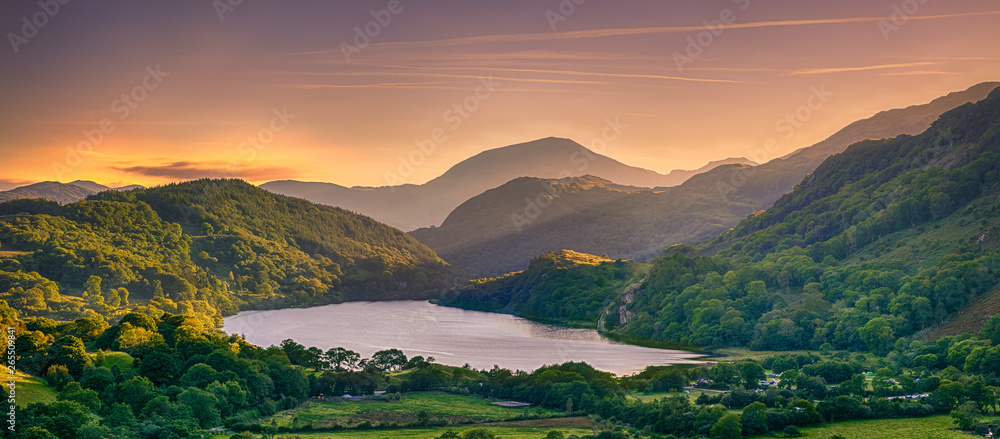 The Sun shining through a mountain pass over Llyn Gwynant, Snowdonia (Eryri), Wales (Cymru), UK - obrazy, fototapety, plakaty 