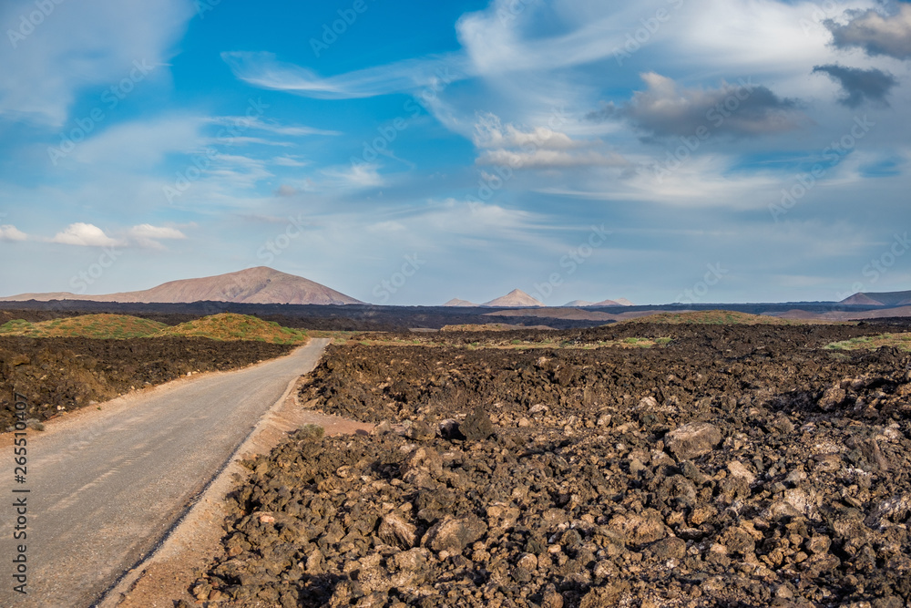 Empty dirtroad into the Lanzarote volcano based desert