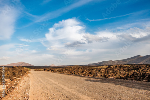 Empty dirtroad into the Lanzarote volcano based desert