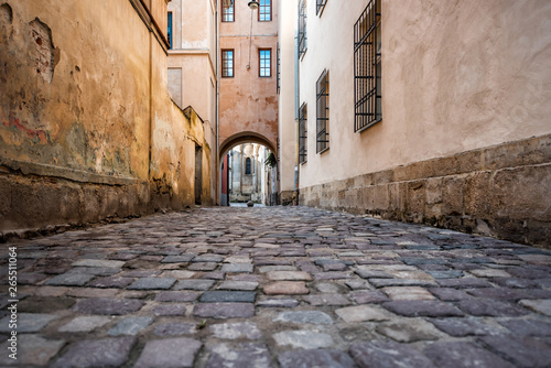 Fototapeta Naklejka Na Ścianę i Meble -  Lviv, Ukraine colorful orange building historical architecture in Ukrainian city with passage archway narrow alley street