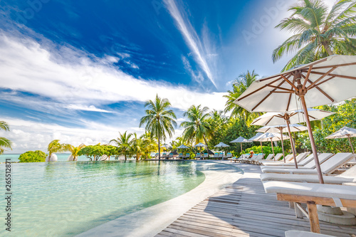 Fototapeta Naklejka Na Ścianę i Meble -  Luxury swimming pool in the tropical hotel or resort. Palm trees and infinity pool close to lounge chairs and umbrellas. Exotic travel destination, summer mood, beach holiday