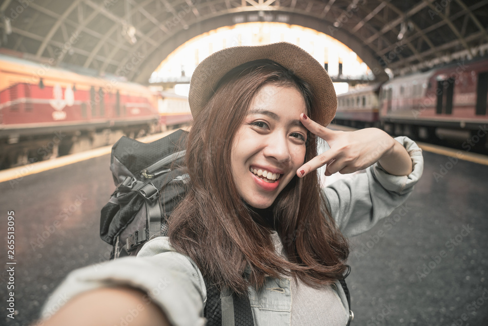 Woman Traveler with backpack traveling taking picture self portrait with smartphone on her summer vacation. Summer Holiday Travel Destination concept.