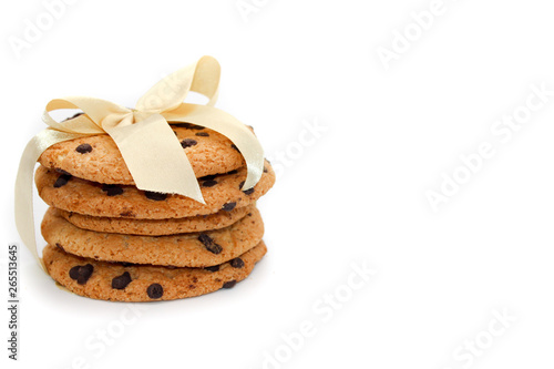 Oatmeal cookies with chocolate drops, tied with a golden ribbon, isolated on white background
