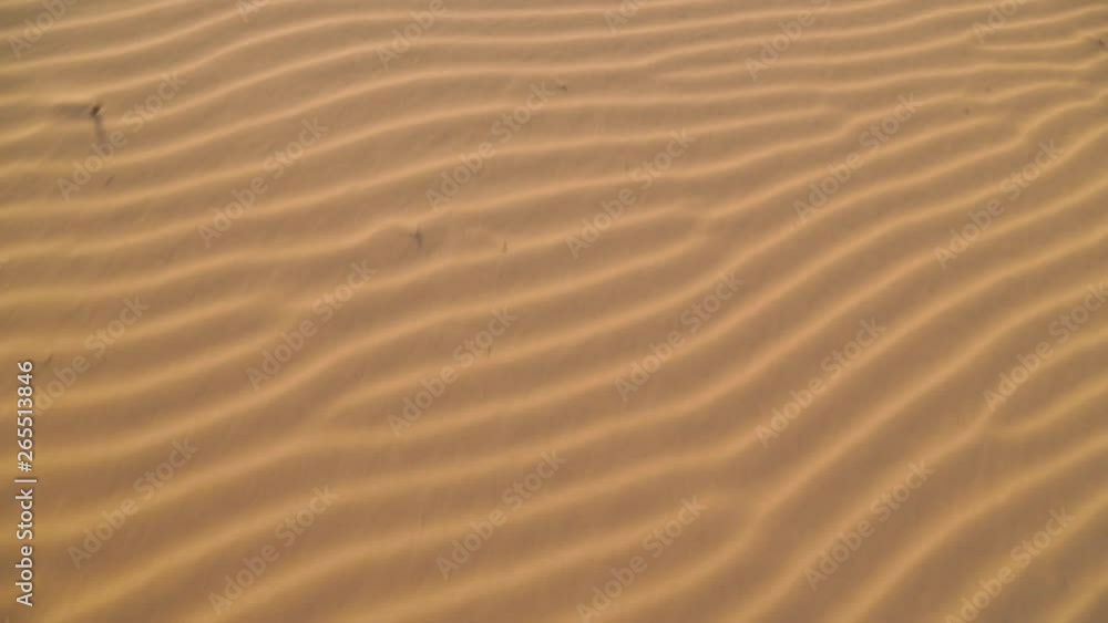 Extreme close-up high-angle front moving shot of beautiful beach sand ripples at the coast, Qld Island, Australia Extreme close-up high-angle front moving shot of beautiful beach sand ripples at the coast, Qld Island, Australia