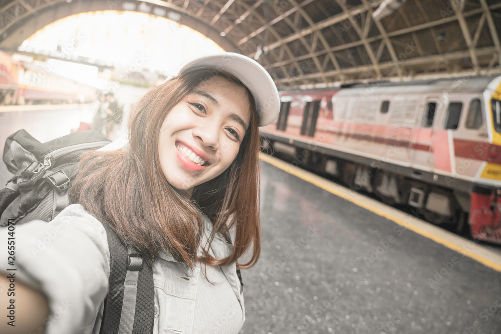 Woman Traveler with backpack traveling taking picture self portrait with smartphone on her summer vacation. Summer Holiday Travel Destination concept.