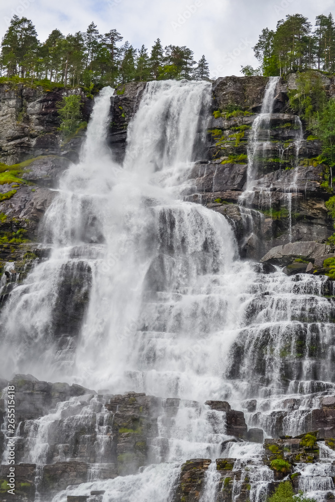 Tvindefossen Waterfall is a gorgeous 152m waterfall near Voss tumbling in strands with a graceful character. Tourism, popular, Norway, Scandinavia Tvindefossen Waterfall is a gorgeous 152m waterfall near Voss tumbling in strands with a graceful character. Tourism, popular, Norway, Scandinavia