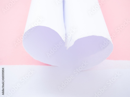 A torn white paper heart-shaped isolated in pastel pink photo