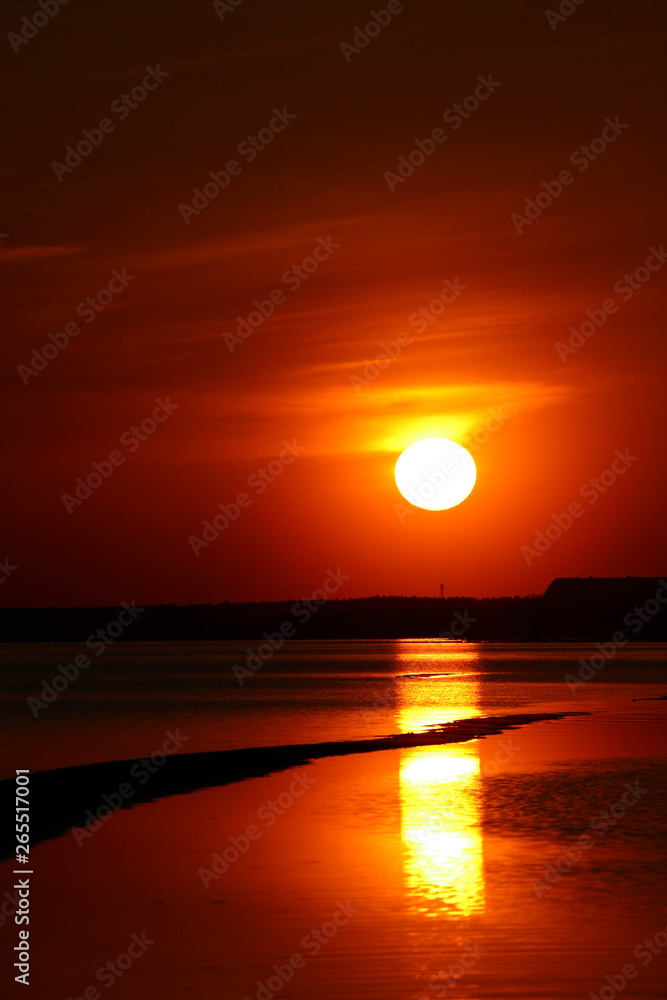 Beautiful orange sunset on the Baltic sea with solar track on the water