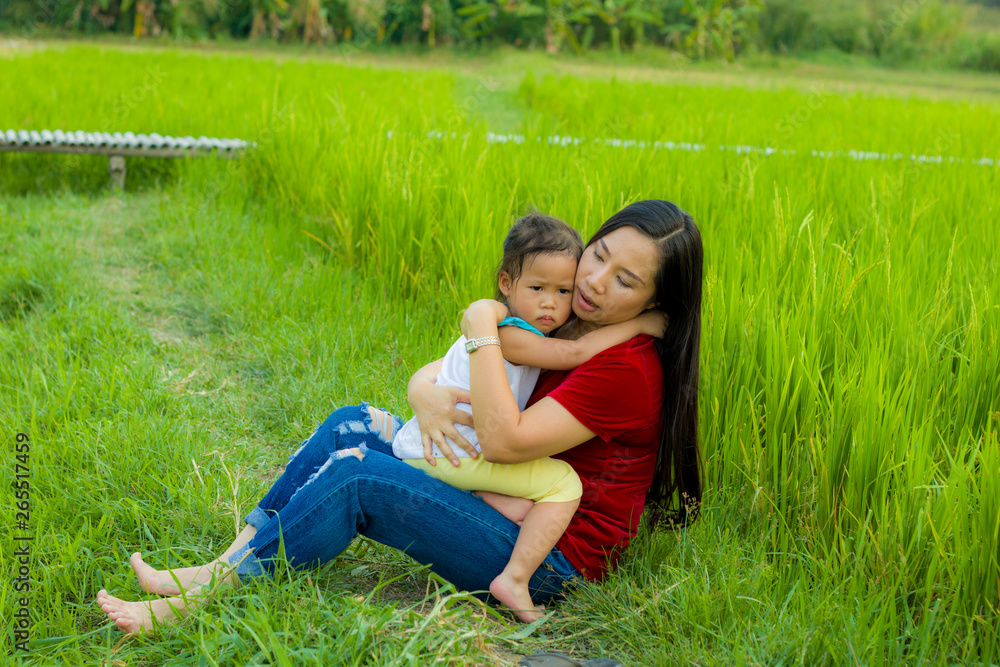 Young mother hugging and soothing a crying little daughter, Asian mother trying to comfort and calm down her crying child Young mother hugging and soothing a crying little daughter, Asian mother trying to comfort and calm down her crying child