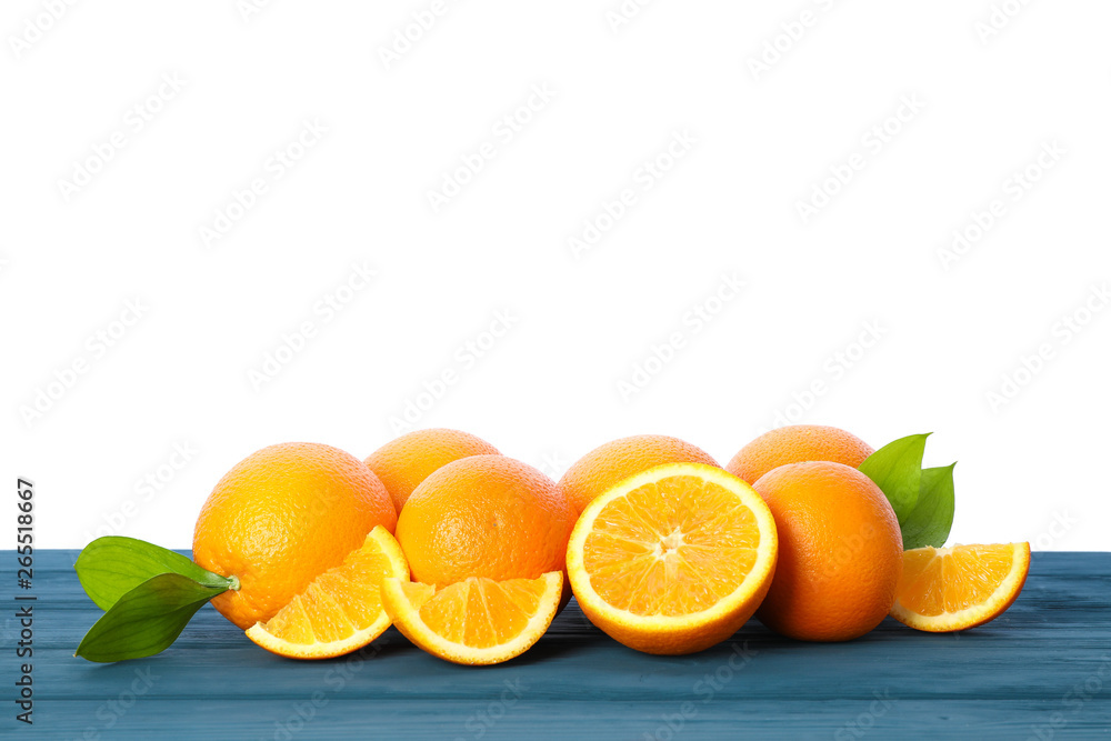 Ripe oranges with leaves on wooden table isolated on white background. Citrus fruit Ripe oranges with leaves on wooden table isolated on white background. Citrus fruit