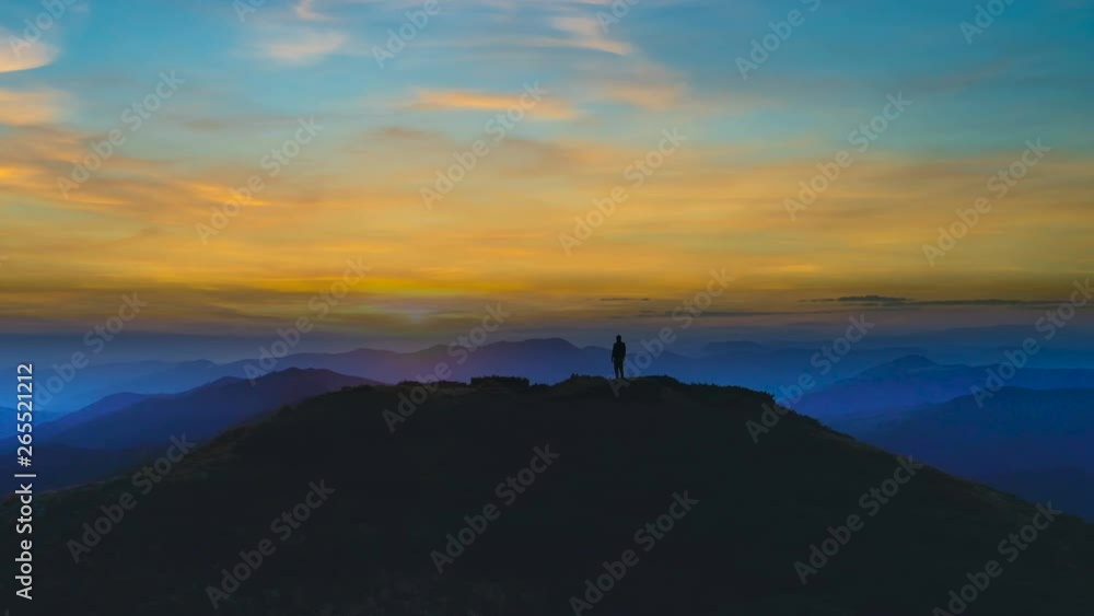 The man silhouette on a mountain against the beautiful sunset The man silhouette on a mountain against the beautiful sunset