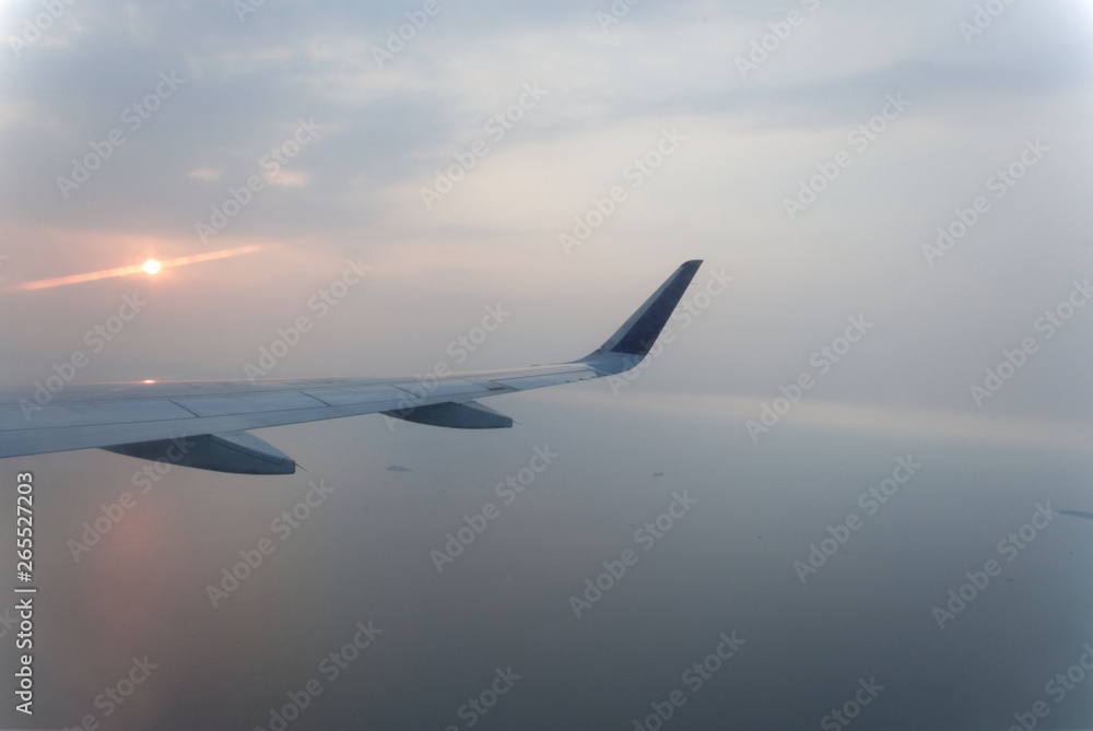 airplane wings during sunset in a clear pinky sky. airplane wings during sunset in a clear pinky sky.