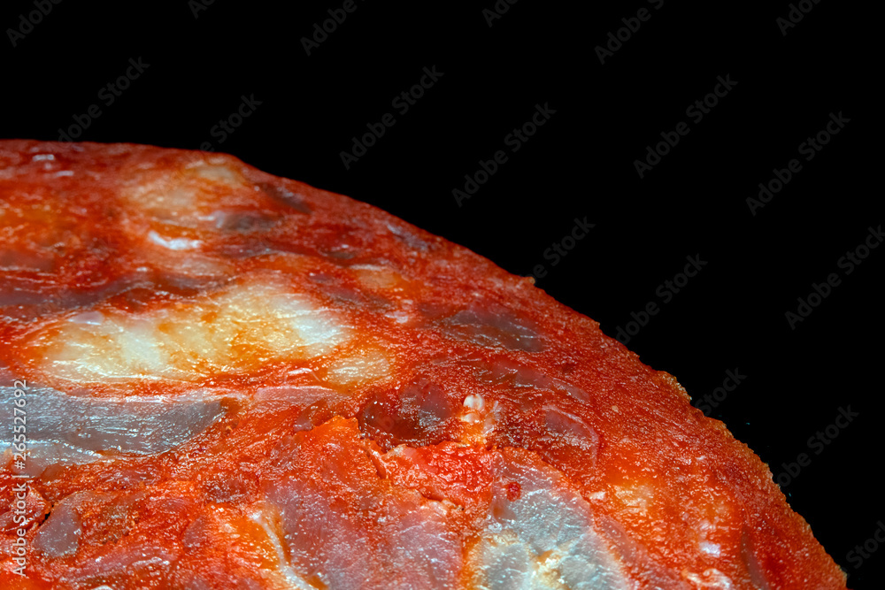 Close Up of a Salami Pepperoni Slice on Black Background Abstract View Close Up of a Salami Pepperoni Slice on Black Background Abstract View