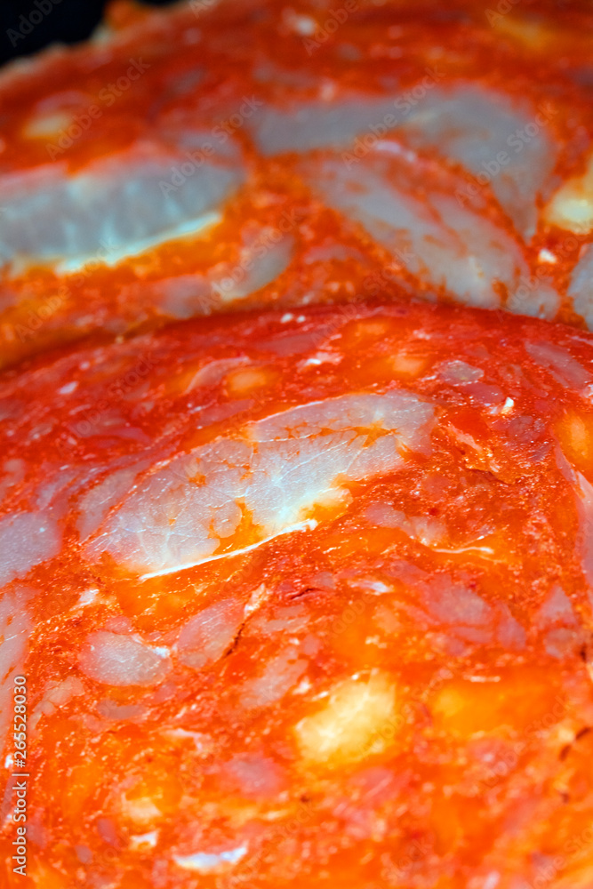 Close Up of a Salami Pepperoni Slice on Black Background Abstract View Close Up of a Salami Pepperoni Slice on Black Background Abstract View