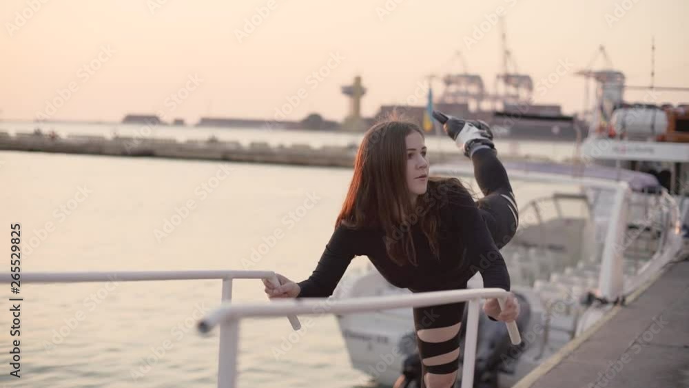 Woman skating by the sea. The girl goes rollerblading and does tricks and stretching on the rollers. Caucasian woman outdoor at sunrise Woman skating by the sea. The girl goes rollerblading and does tricks and stretching on the rollers. Caucasian woman outdoor at sunrise