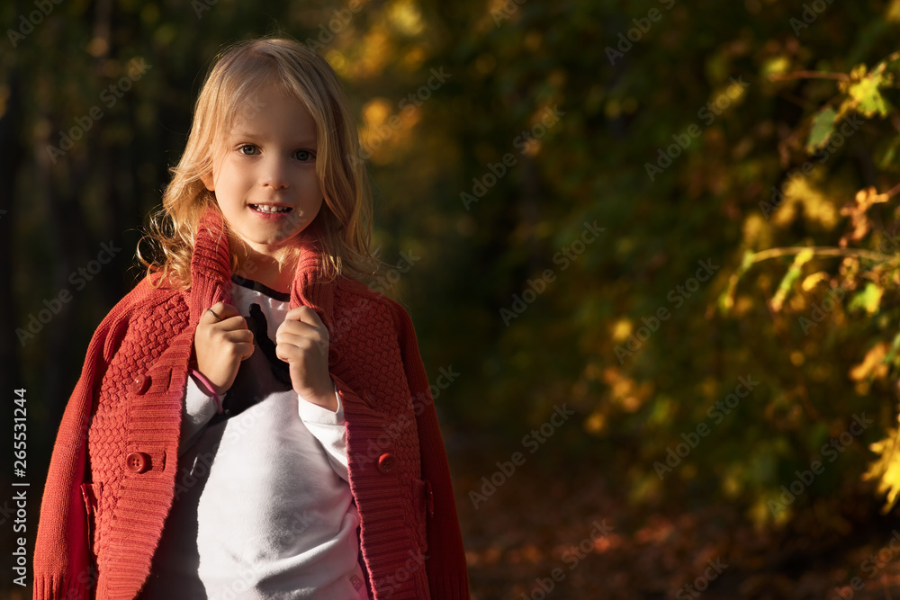Cute little girl playing in the autumn park. Happy child, among the fallen leaves. Autumn children's fashion. Happy childhood Fashionable little girl. Lifestyle, people and autumn concept Cute little girl playing in the autumn park. Happy child, among the fallen leaves. Autumn children's fashion. Happy childhood Fashionable little girl. Lifestyle, people and autumn concept